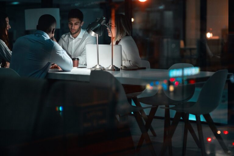 Group, brainstorming and night in meeting, laptop and planning of teamwork, deadline and project for website. Business, computer and admin assistant, online and people in boardroom, dark and startup